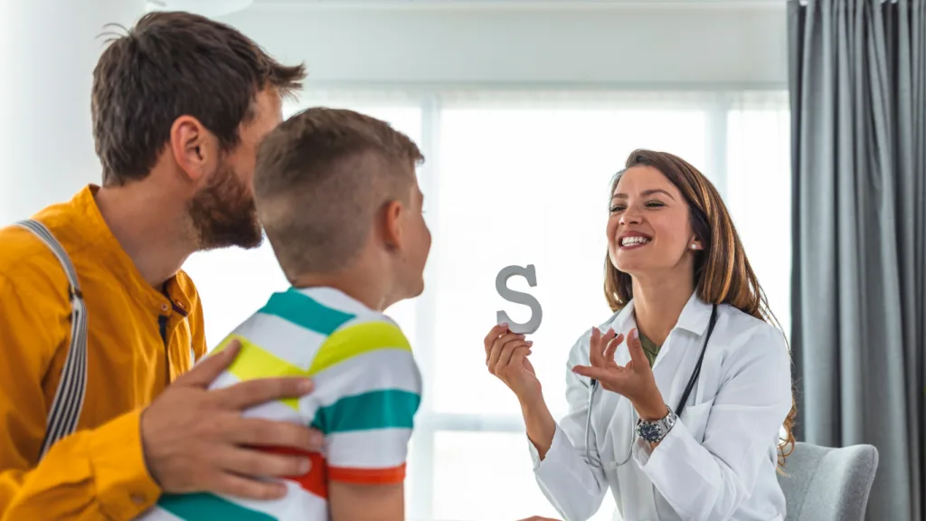 Female Medisense speech pathologist helping boy in speech pathology exercise in Australia