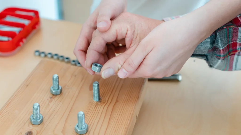 Man in Occupational Therapy Screwing Nut on Bolt