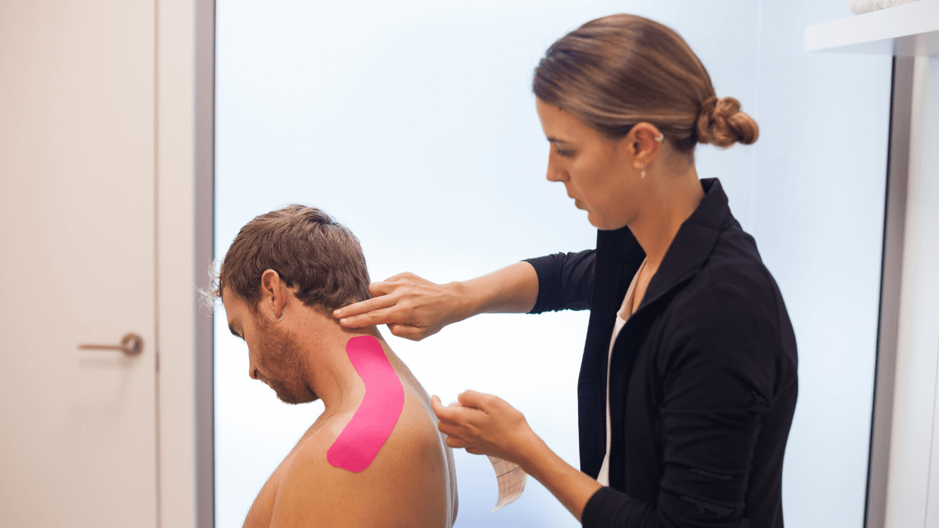 Physiotherapist Applying Kinesiology Tape on Her Patient's Shoulder