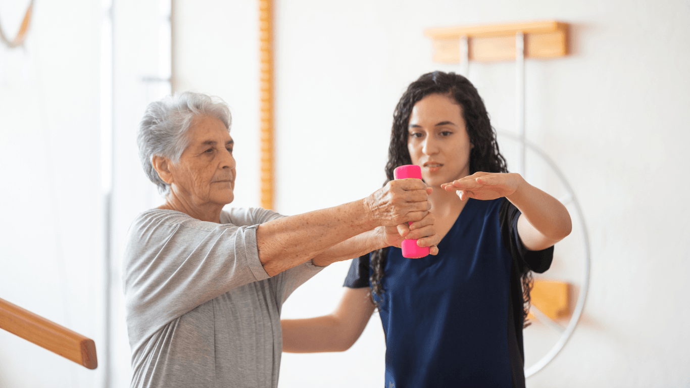 Senior woman lifting weight during physical therapy with occupational therapist