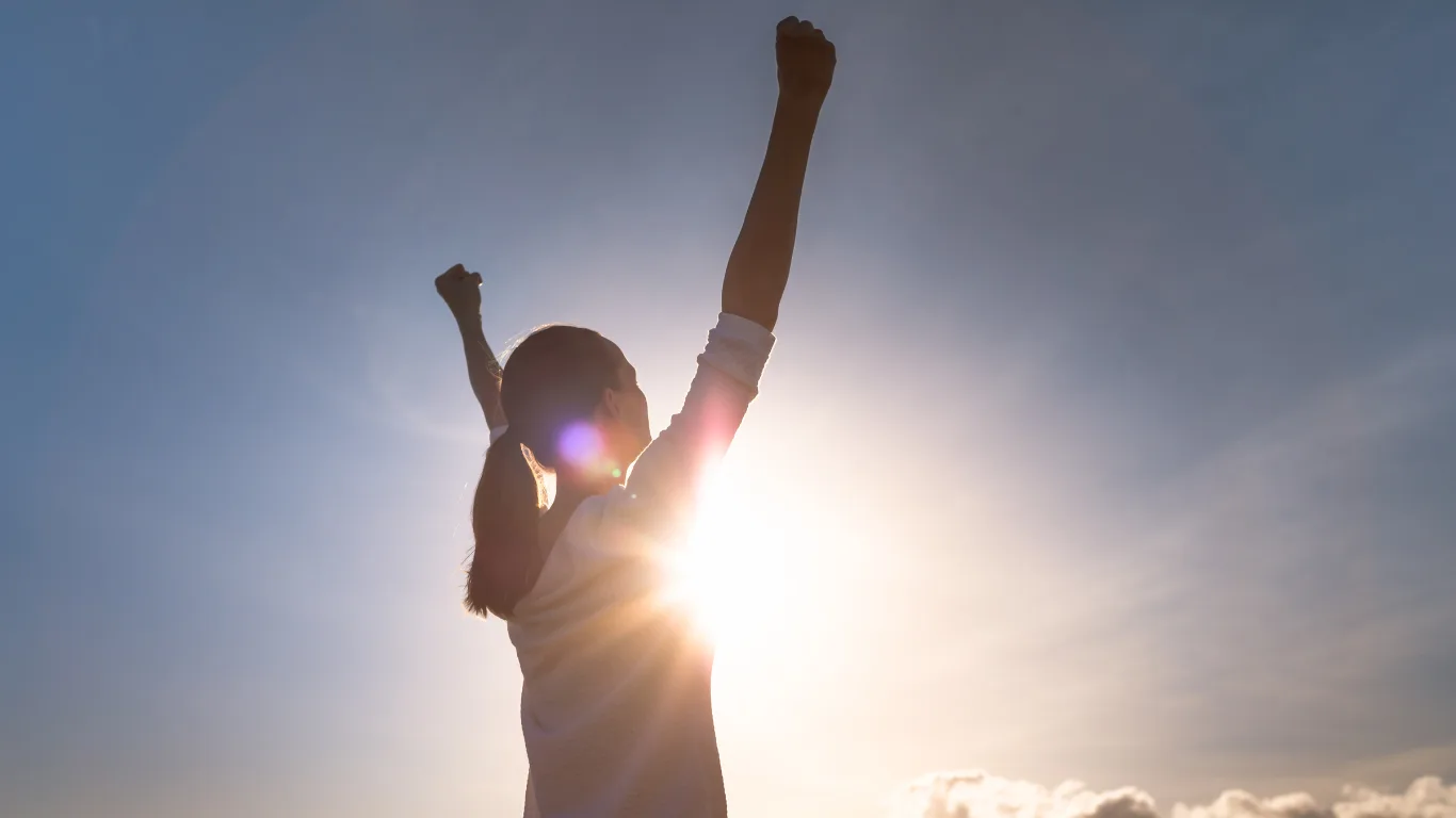 Strong woman overcoming adversity. Woman with fist up to the sky