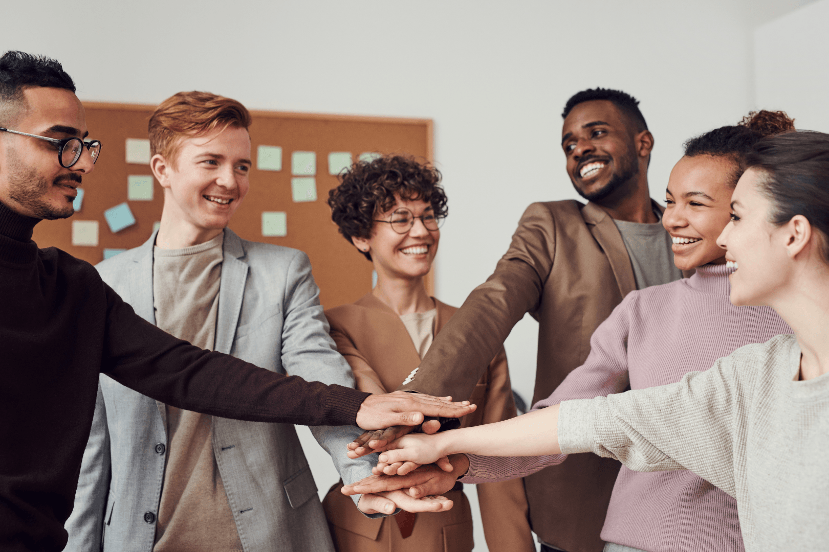 Diverse team of health care professionals huddled with hands together